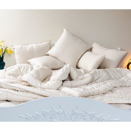 Oreillers naturels, respirants et sains posés sur un matelas en laine